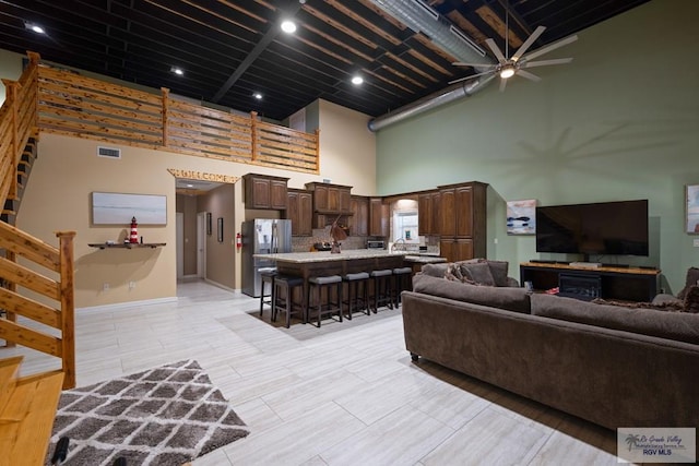 living room featuring a towering ceiling and ceiling fan