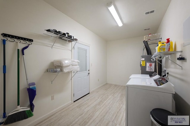 laundry room with separate washer and dryer, light hardwood / wood-style flooring, and water heater