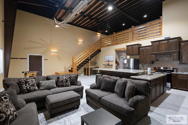 living room featuring a towering ceiling and ceiling fan