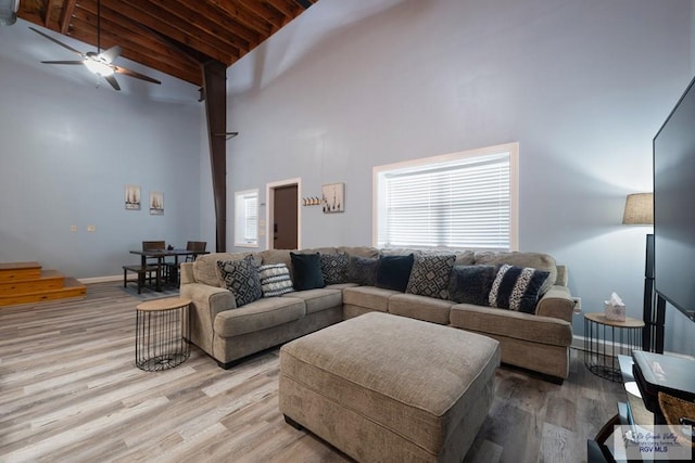 living room with beam ceiling, wooden ceiling, high vaulted ceiling, and light hardwood / wood-style flooring