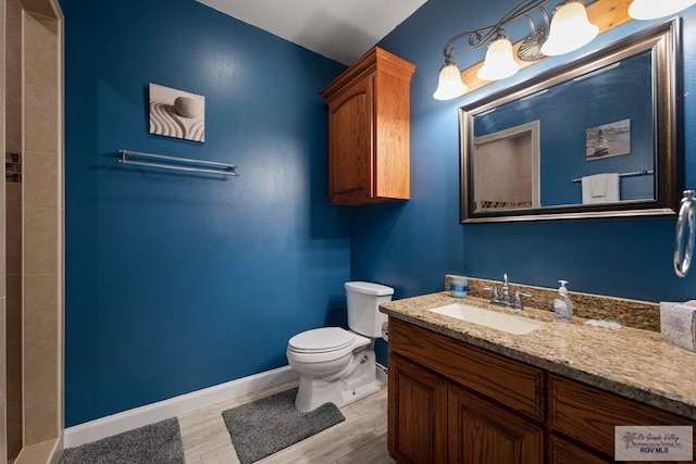 bathroom with toilet, vanity, and hardwood / wood-style flooring