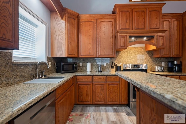 kitchen with backsplash, sink, light hardwood / wood-style floors, and appliances with stainless steel finishes