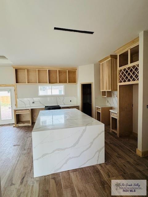 825 Milania Dr, La Feria, TX 78589 - kitchen with open shelves, dark wood-type flooring, a kitchen island, and light stone countertops