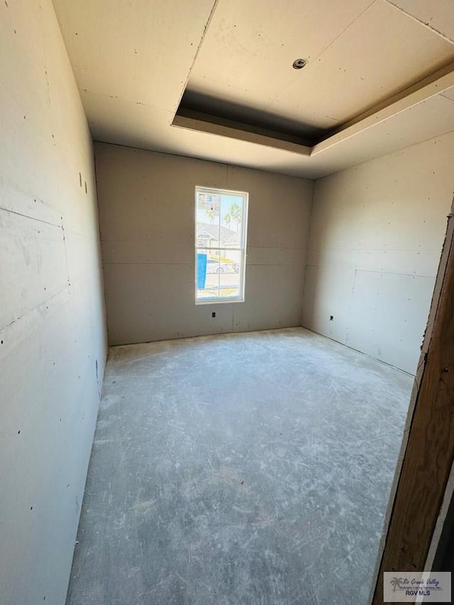 825 Milania Dr, La Feria, TX 78589 - spare room featuring unfinished concrete flooring and a tray ceiling