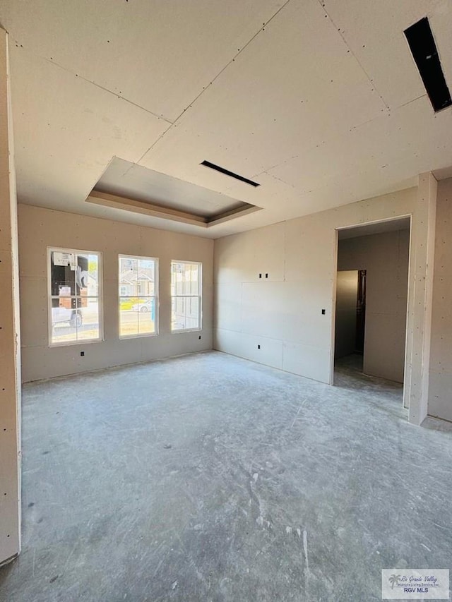 825 Milania Dr, La Feria, TX 78589 - empty room with a tray ceiling and concrete floors