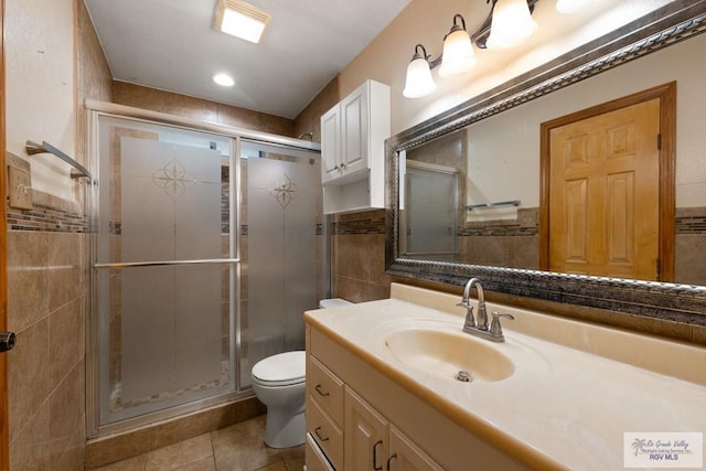 bathroom featuring tile patterned flooring, vanity, toilet, and a shower with door