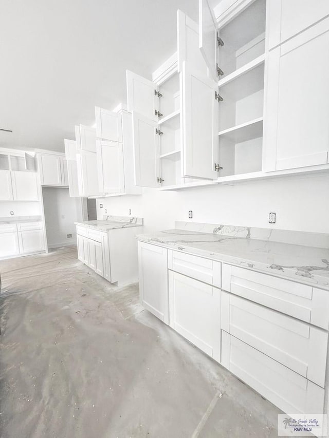 kitchen with white cabinetry and light stone counters