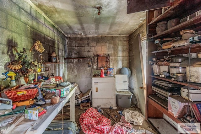 miscellaneous room with separate washer and dryer and concrete block wall