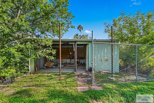 back of house featuring fence and an outbuilding