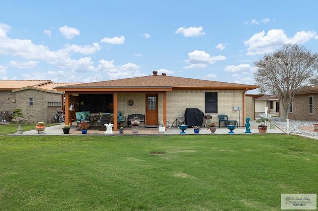 rear view of property with a lawn and a patio area