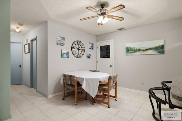 dining space featuring light tile patterned floors, a textured ceiling, and ceiling fan