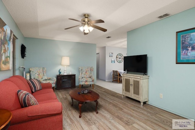 living room featuring ceiling fan and light hardwood / wood-style flooring