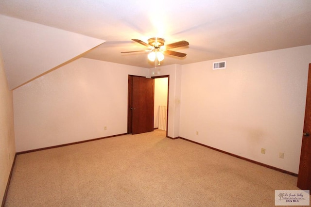 bonus room featuring ceiling fan and light colored carpet