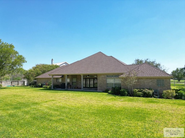 back of property featuring ceiling fan and a lawn