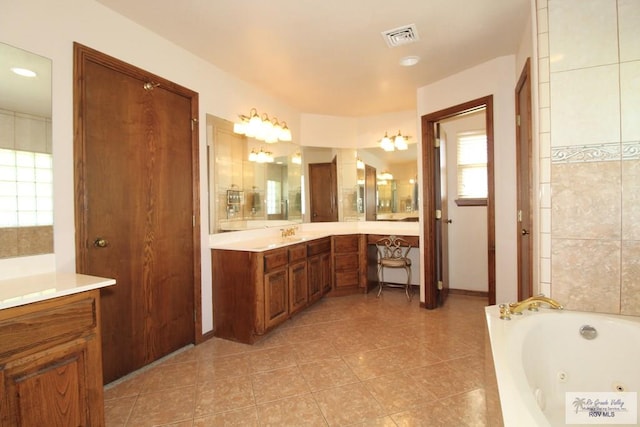 bathroom featuring tile patterned floors, vanity, and a bath