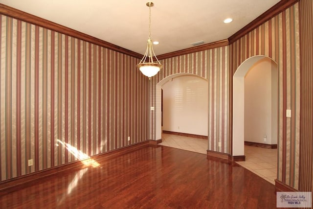 spare room featuring ornamental molding and light hardwood / wood-style flooring