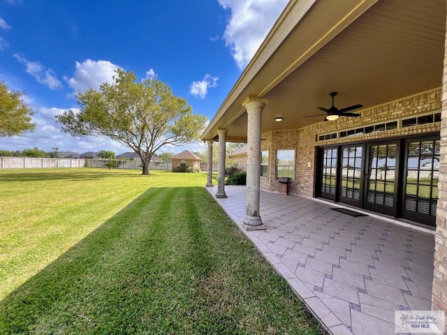 view of yard with ceiling fan and a patio