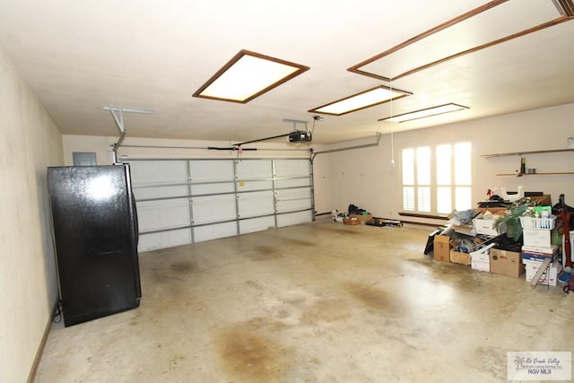 garage with a garage door opener and black fridge