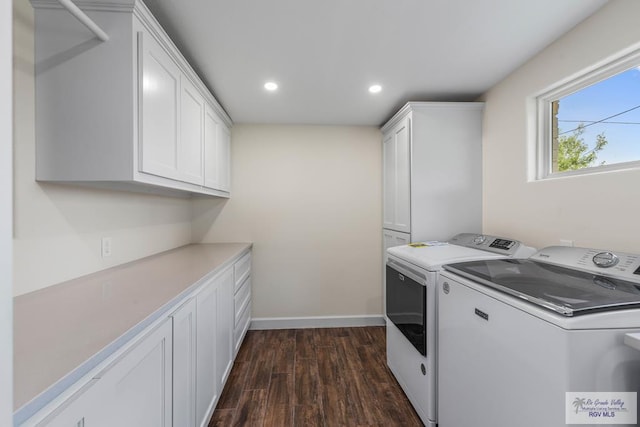 washroom featuring washer and clothes dryer, dark hardwood / wood-style floors, and cabinets