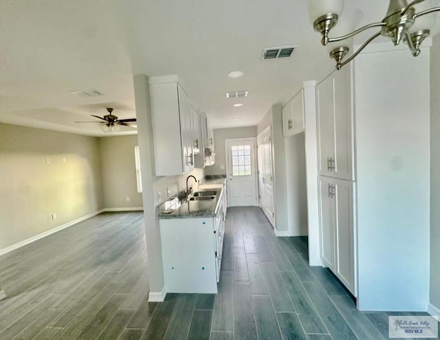 kitchen featuring dark hardwood / wood-style flooring, ceiling fan, sink, and white cabinetry