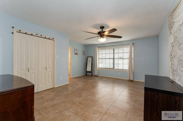 interior space with ceiling fan and light tile patterned flooring