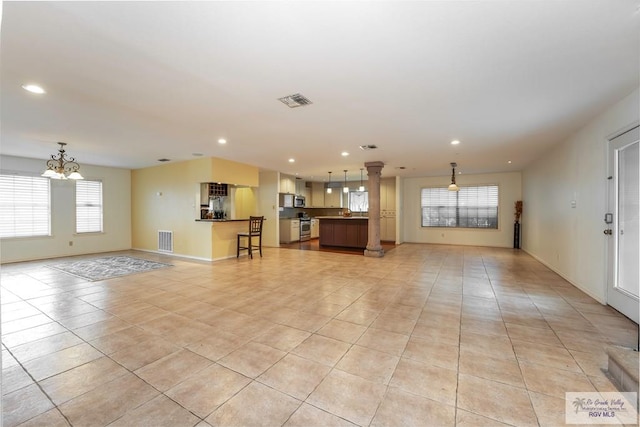 unfurnished living room with light tile patterned floors and a notable chandelier