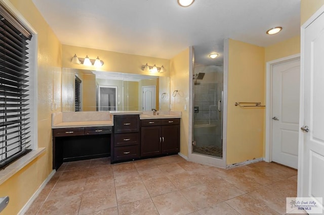 bathroom with tile patterned floors, vanity, and walk in shower