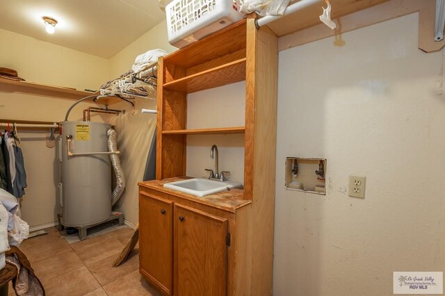 utility room with electric water heater and sink