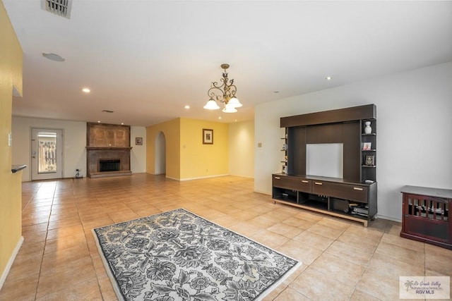 tiled living room featuring a fireplace and a chandelier