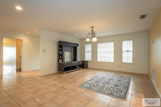 unfurnished living room featuring a notable chandelier and light tile patterned flooring