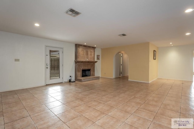 unfurnished living room with a fireplace and light tile patterned floors