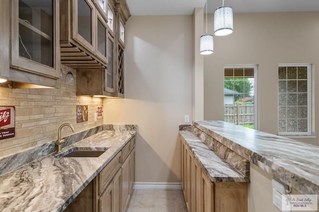 2402 S Christian Cir, Harlingen, TX 78550 - kitchen featuring light stone countertops, tasteful backsplash, hanging light fixtures, glass insert cabinets, and a towering ceiling
