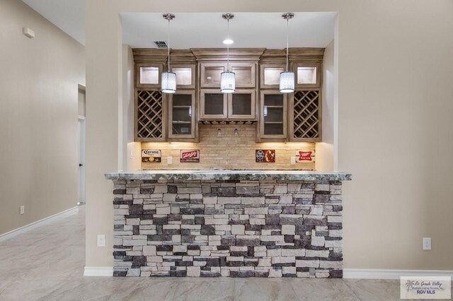 2402 S Christian Cir, Harlingen, TX 78550 - indoor dry bar featuring decorative backsplash, hanging light fixtures, and light marble finish flooring