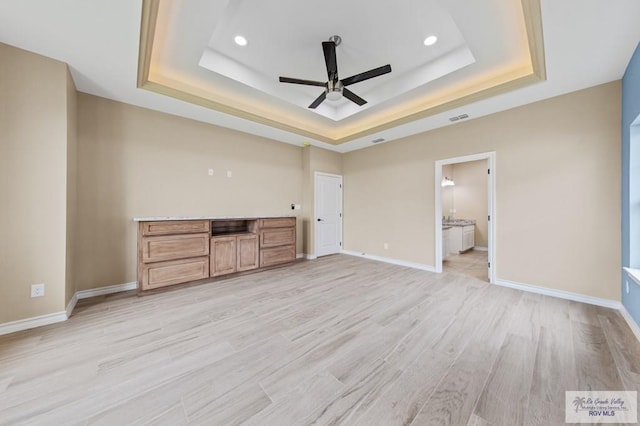 2402 S Christian Cir, Harlingen, TX 78550 - unfurnished living room featuring a tray ceiling, a ceiling fan, recessed lighting, and light wood finished floors
