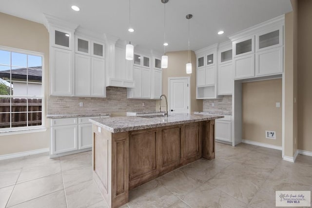2402 S Christian Cir, Harlingen, TX 78550 - kitchen with light marble finish flooring, a center island with sink, backsplash, white cabinetry, and recessed lighting