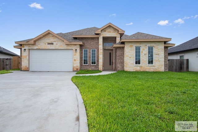 2402 S Christian Cir, Harlingen, TX 78550 - view of front of home with an attached garage, driveway, stone siding, and roof with shingles