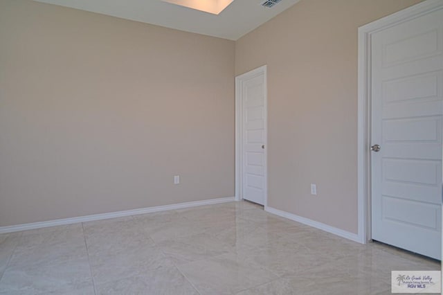 unfurnished room with visible vents and baseboards