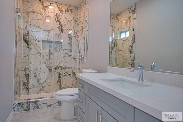 bathroom with vanity, a marble finish shower, and toilet