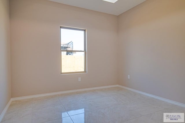 unfurnished room with baseboards