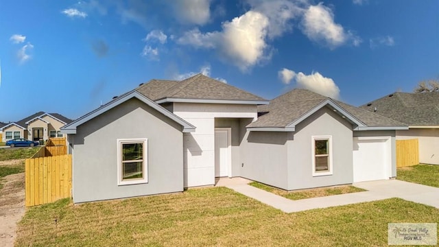 view of front of home with an attached garage, a shingled roof, fence, stucco siding, and a front yard