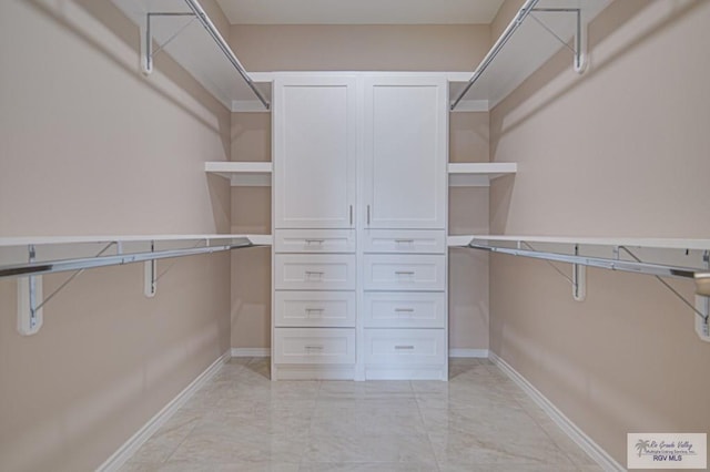 spacious closet featuring marble finish floor