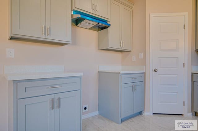 clothes washing area with baseboards