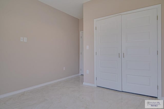 unfurnished bedroom featuring a closet and baseboards