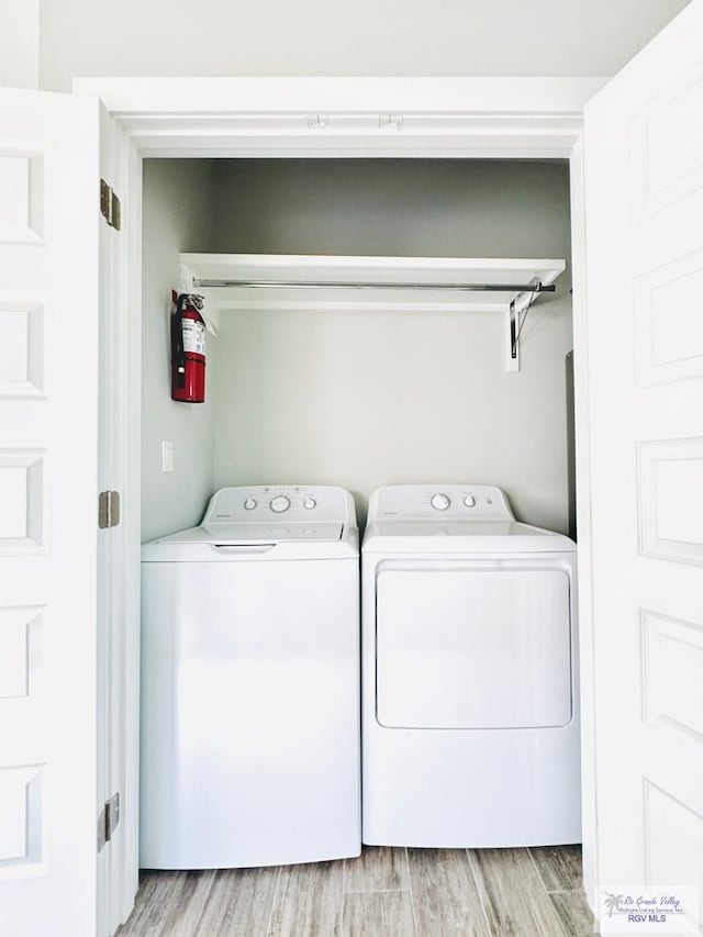 laundry area featuring light wood-type flooring and separate washer and dryer