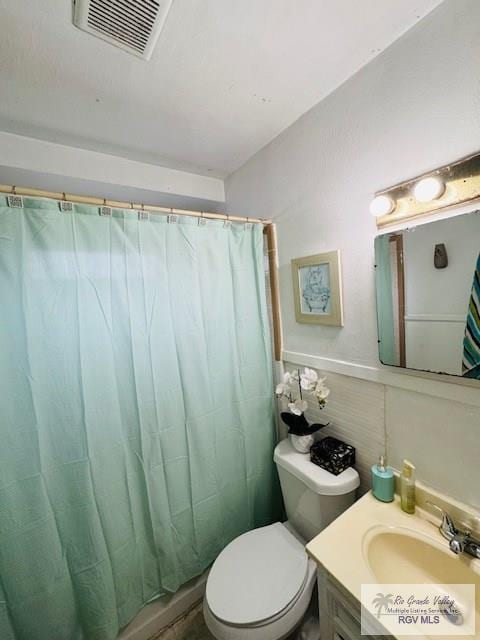 bathroom with walk in shower, vanity, and toilet