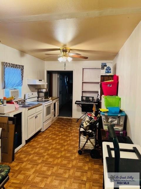 kitchen featuring white electric range oven, ceiling fan, white cabinetry, and light parquet flooring