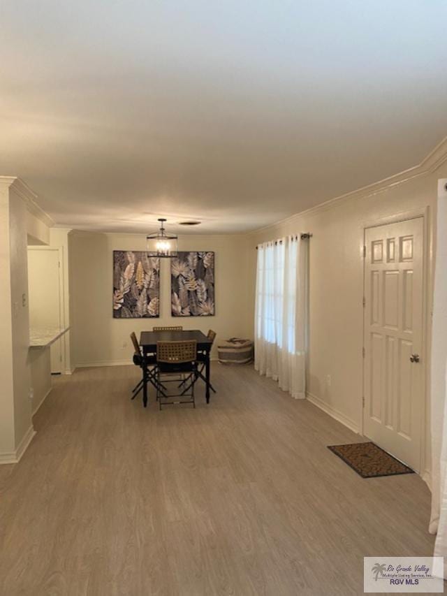 dining room featuring a chandelier, hardwood / wood-style flooring, and crown molding