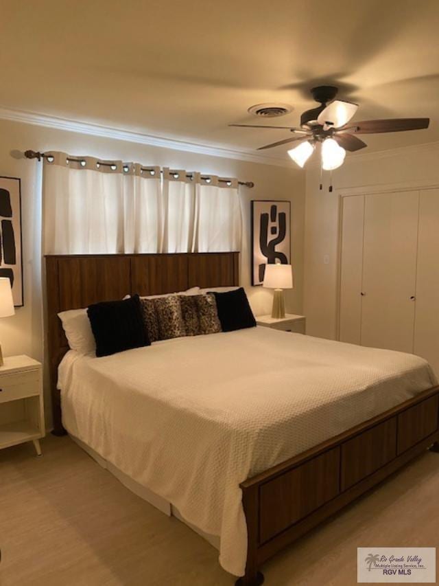 bedroom featuring light wood-type flooring, ceiling fan, and crown molding