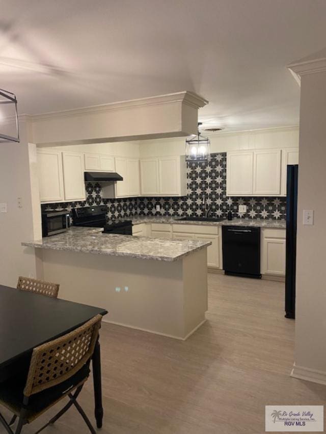 kitchen featuring tasteful backsplash, light stone counters, kitchen peninsula, white cabinets, and black appliances