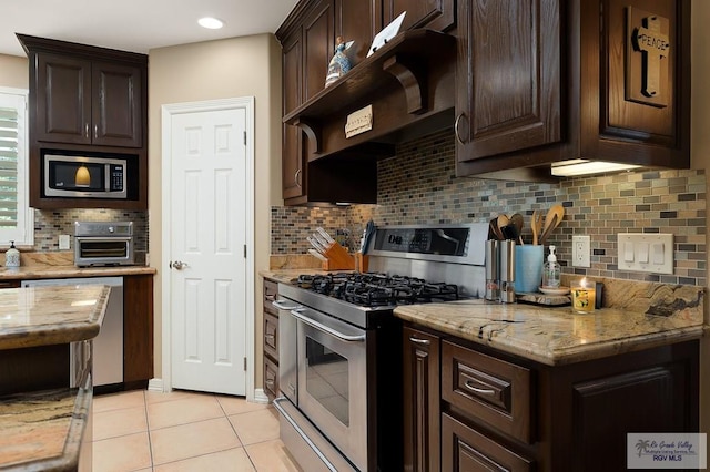 kitchen featuring dark brown cabinets, decorative backsplash, light stone countertops, and appliances with stainless steel finishes